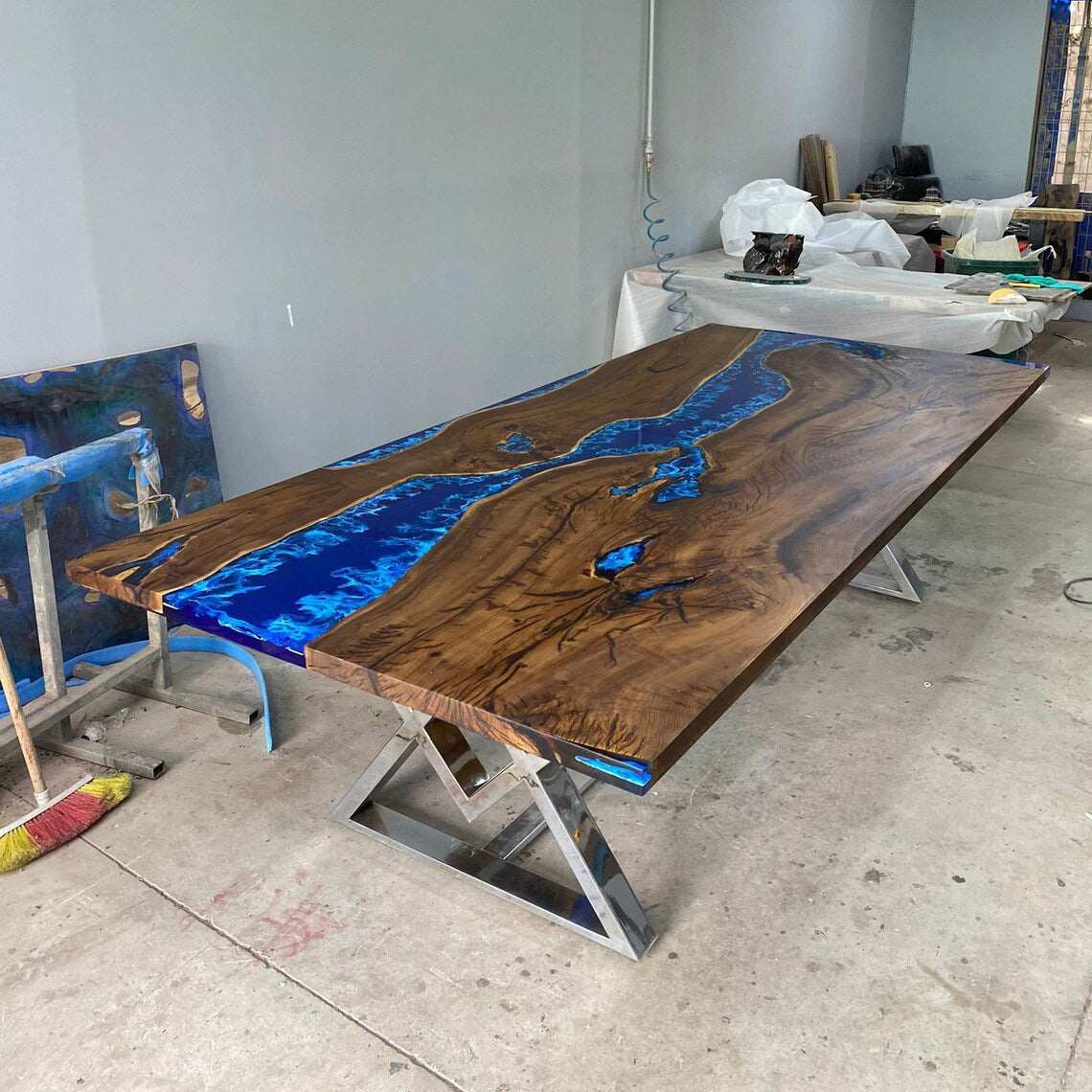 Atlantic Walnut Dining Table with deep blue epoxy river and silver geometric metal base