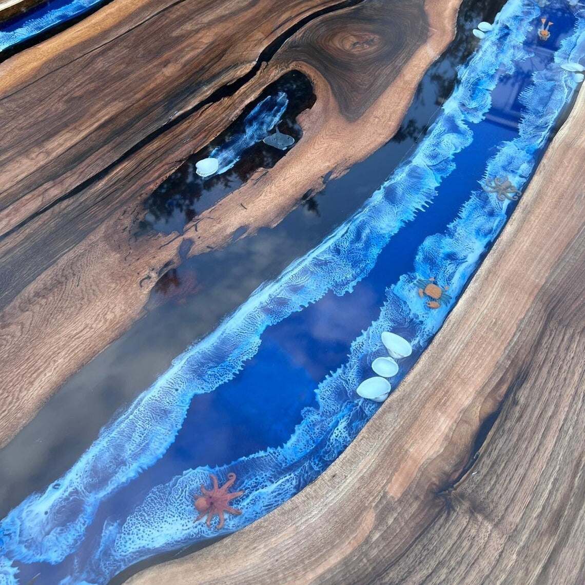 Pacific Crest live edge walnut dining table with ocean-blue resin core and waterfall edges