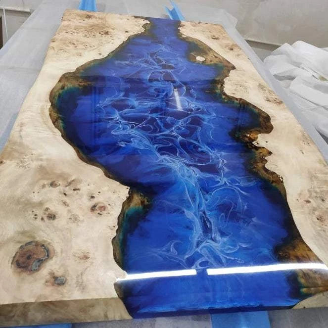 Cascade Burl Dining Table with ocean blue resin river and geometric silver metal base