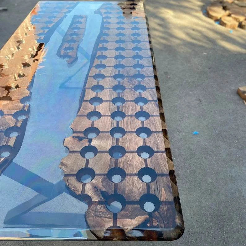 Walnut conference table with geometric circular cutouts and clear resin river featuring a floating wood island, supported by modern black metal legs