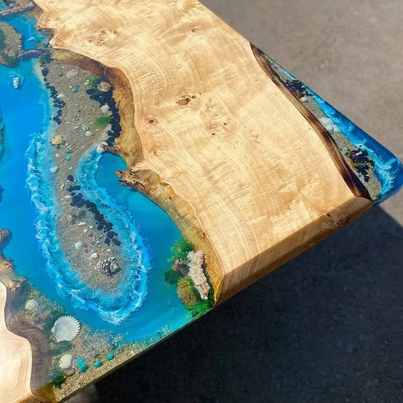 Archipelago Poplar Dining Table with live-edge wood, ocean blue resin river, miniature islands, and black metal base