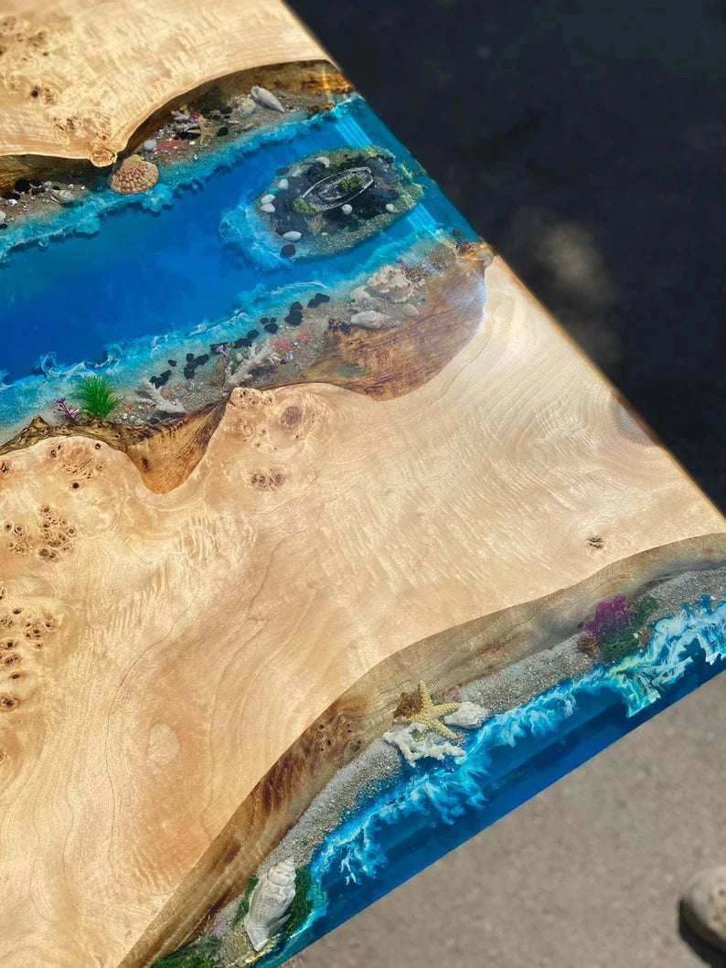 Archipelago Poplar Dining Table with live-edge wood, ocean blue resin river, miniature islands, bridges, and black metal base